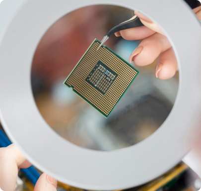 A scientist using tweezers to inspect a semiconductor chip